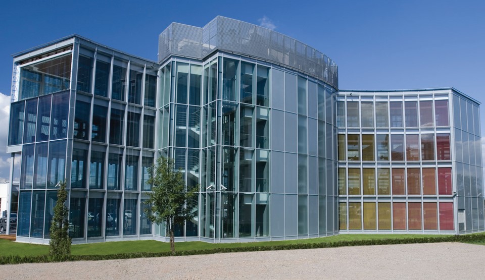 Vollverglastes Bürogebäude mit Stellflächen für Autos